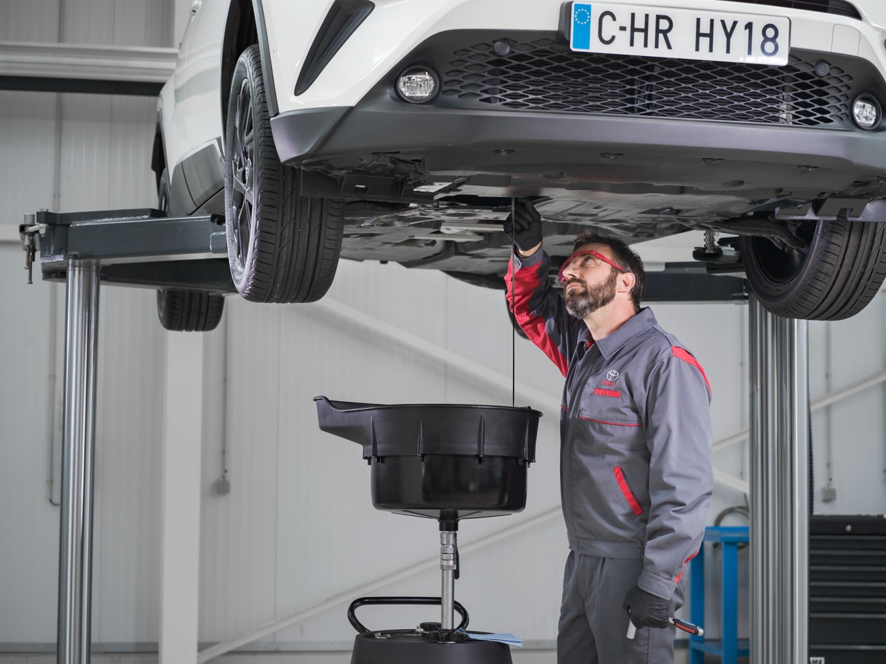 Technician working on bottom of car